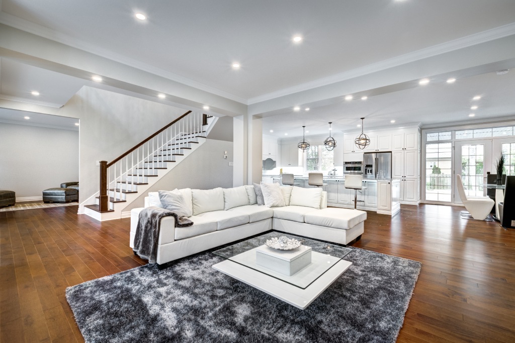 Luxury Open Concept Living Room and Kitchen with Cherry Hardwood Floors White Sectional Sofa and Orb Pendant Lights.jpg